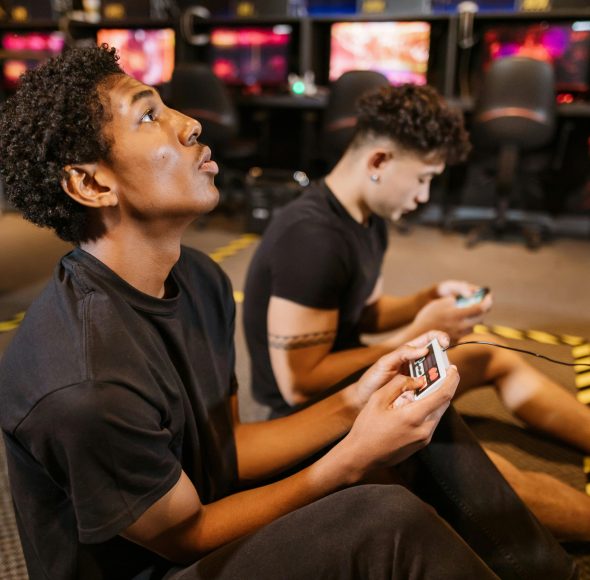Two teenagers deeply engaged in a video gaming session at an indoor arcade.