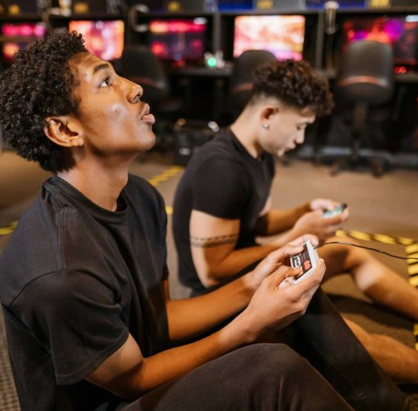 Two teenagers deeply engaged in a video gaming session at an indoor arcade.