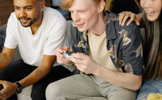 Close-knit group of friends immersed in a video game session at home, showcasing diversity and leisure.